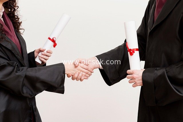 Graduation Ceremony Handshake with Red Ribbon Certificates in Business Setting