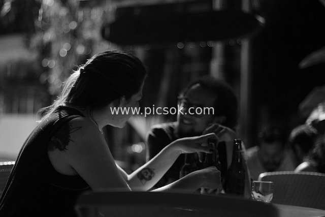 Black-and-White Atmospheric Moment of a Couple’s Warm Conversation at a Bar