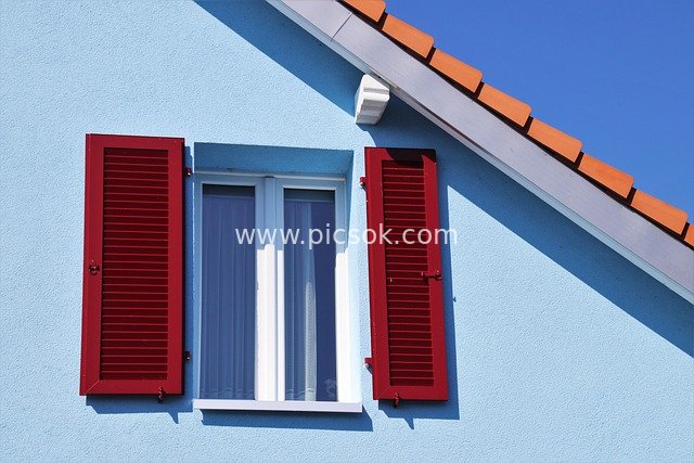Rural House Window with Blue Walls and Red Shutters