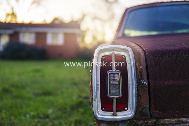 Vintage Rusty Car Tail Light at Sunset in American Suburbs