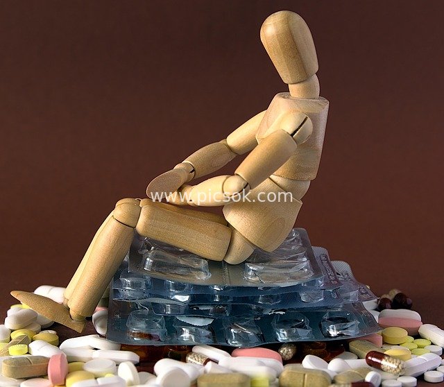 Wooden Mannequin Lying on a Pile of Medicines: A Symbol of Drug Addiction, Depression, and Despair
