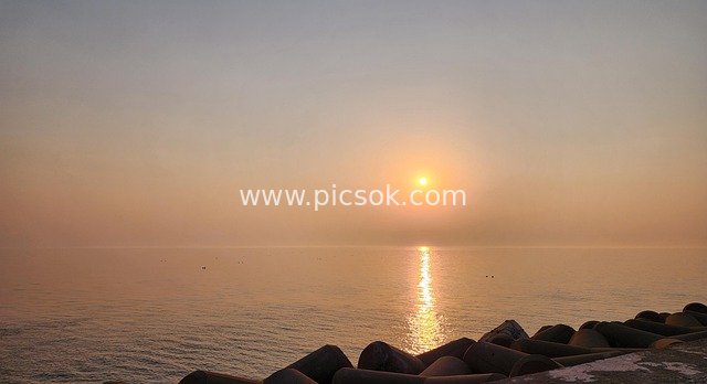 Seaside Sunset: A Serene Coast with Golden Sea Surface and Sunset Reflections