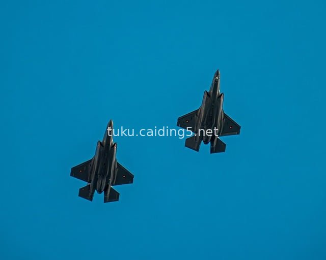 Two F-35 Stealth Fighters Flying in Formation Against Blue Sky