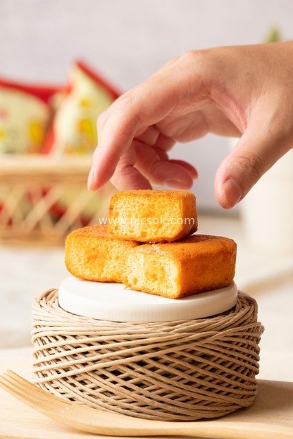 手取美味玉米面包 木质场景美食素材图