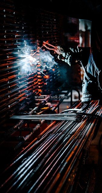 Industrial Welding Scene: Dazzling Sparks Burst from Welder’s Work