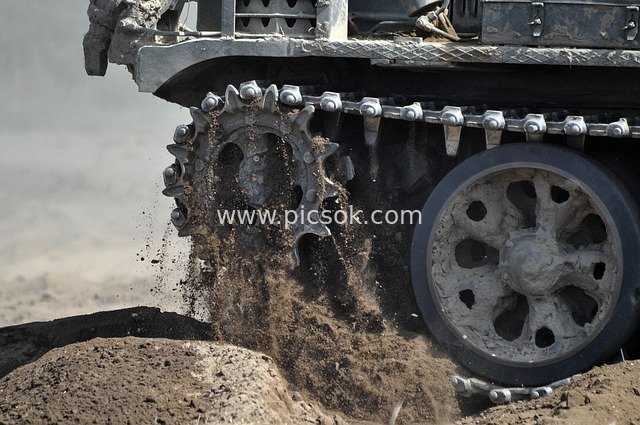 主战坦克履带运转扬起沙尘的军事装备场景