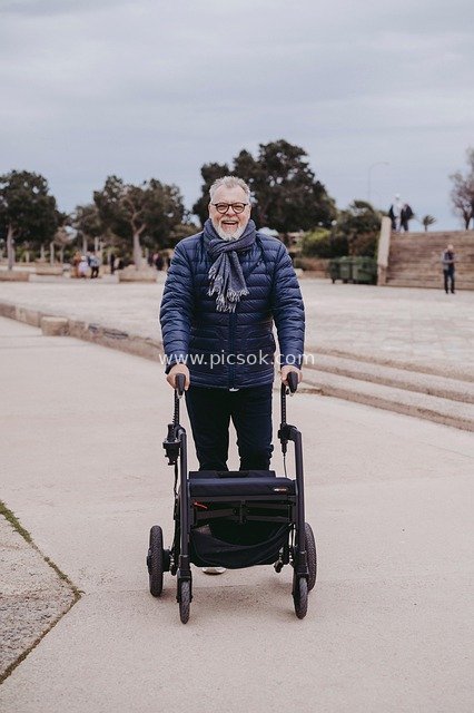 Smiling Elderly Man Walking Outdoors with Modern Walker
