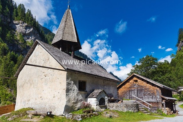 Stone Church and Wooden Chalet in Alpine Valley, St. Martin Carfesenthal