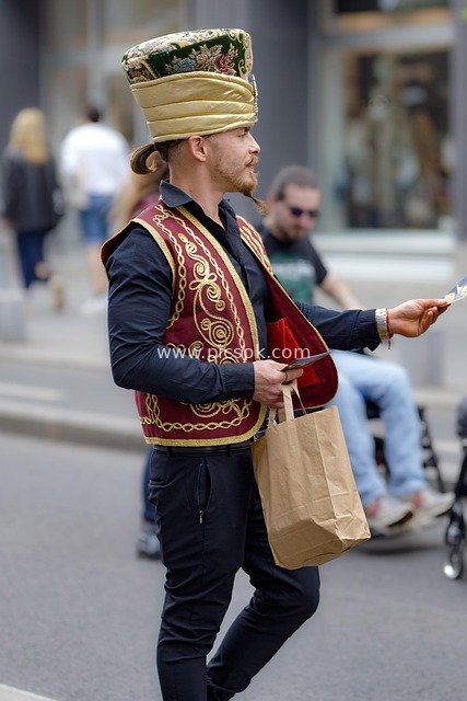 Man in Retro Attire Distributing Leaflets on City Street – Advertising Promotion Scene