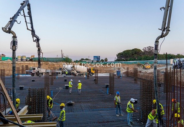 Concrete Pouring at Construction Site: Workers and Machinery Collaborating