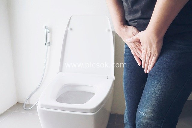 Woman in Jeans in Bathroom, Showing Urgency to Use the Toilet