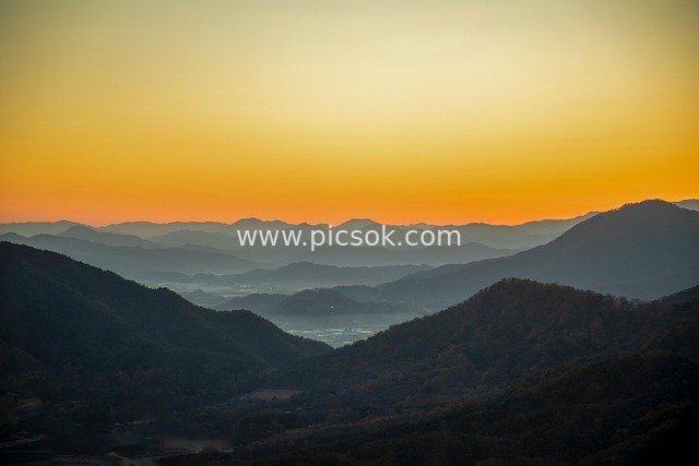 层峦叠嶂日出山间 暖色调自然风景图