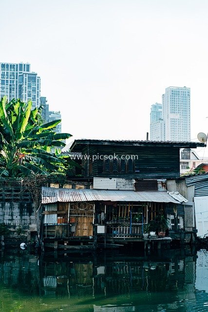 Contrasting Scenery of Floating Wooden Houses and Urban Skyscrapers in Bangkok