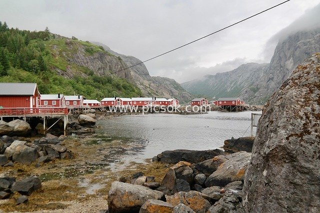 Red Stilt Houses on Norway’s Lofoten Coast: Summer Scenery with Misty Mountains