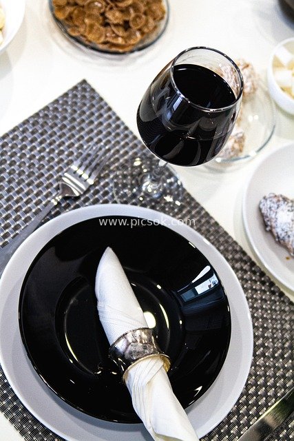 优雅餐宴布置：红酒杯与黑白餐盘的精致搭配