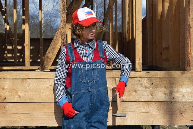Female Construction Worker Holding a Hammer at a House Construction Site