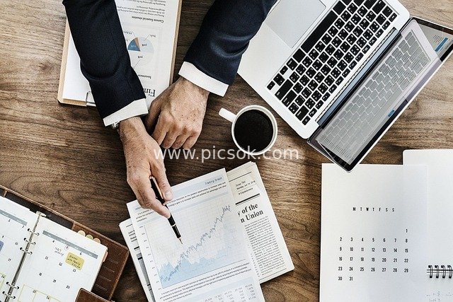 Business Professional Analyzing Stock Charts - Overhead Shot of Office Scene