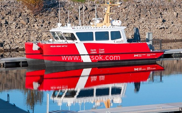 Red-and-White Coast Guard Boat Docked at Pier with Clear Water Reflection
