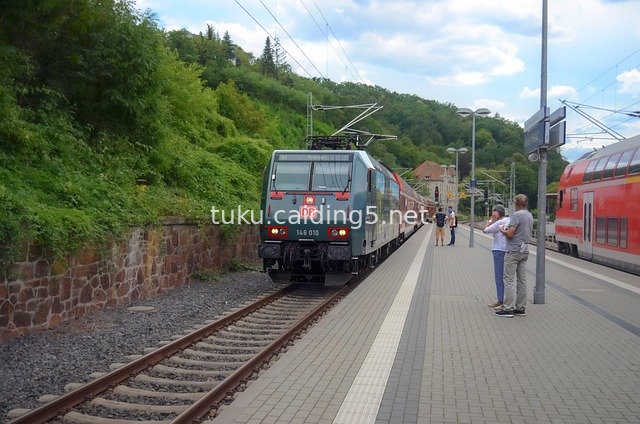 Red Trains and Passengers at a Railway Platform: Daily Travel Scene