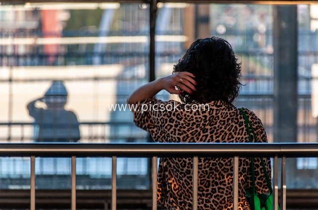 Back View of a Leopard-Print Woman Waiting at a Station: The Moment She Brushes Her Hair