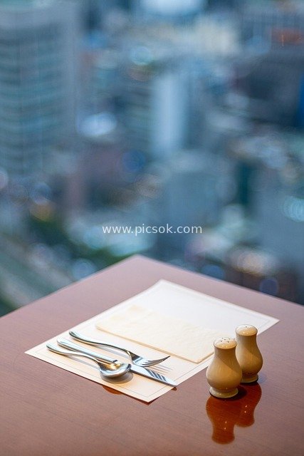 高层餐厅餐桌餐具盐椒瓶 城市景观背景