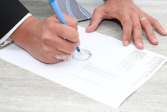 Business Professional Signing a Stamped Document – Moment of Formal Contract Signing
