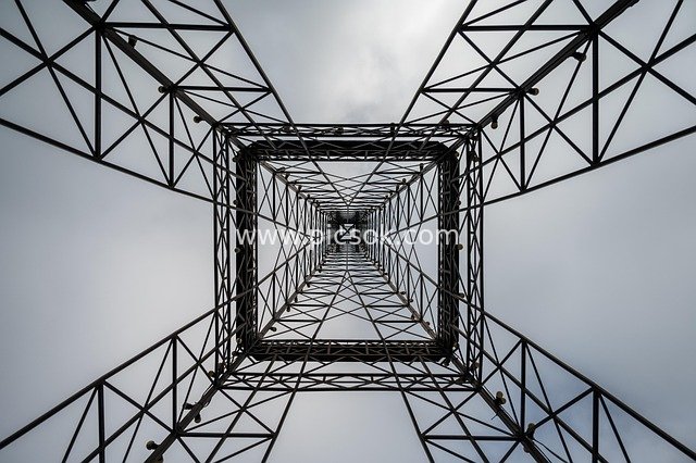 Looking Up at the Steel Structure Frame of a Power Transmission Tower on an Overcast Day - Industrial Infrastructure