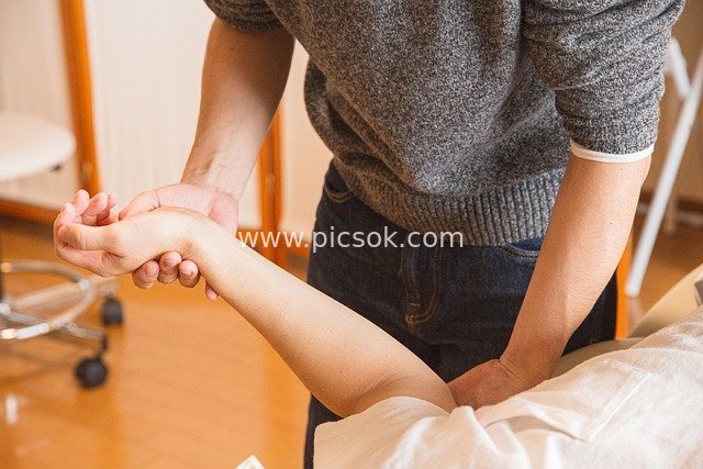 Rehabilitation Therapist Performing Massage and Rehabilitation Care for a Patient
