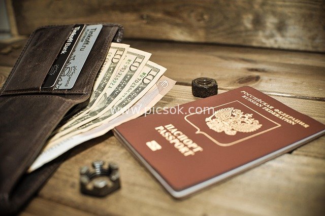 Passport, Wallet, US Dollars and Financial Elements on a Wooden Desktop