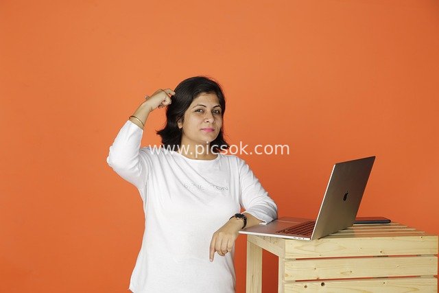 Professional Woman Contemplating Creativity in Laptop Office Scene