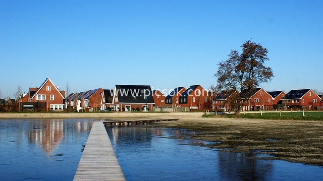 Red-Roofed Houses by Water in Dutch Countryside, Stunning Reflections of Wooden Boardwalks