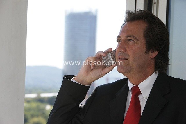 Business Elite Making a Call Outdoors - Professional Image in Suit and Red Tie