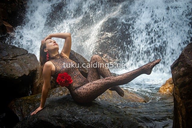 Model in Leopard Print Jumpsuit Poses Elegantly in Front of a Waterfall in Sri Lanka