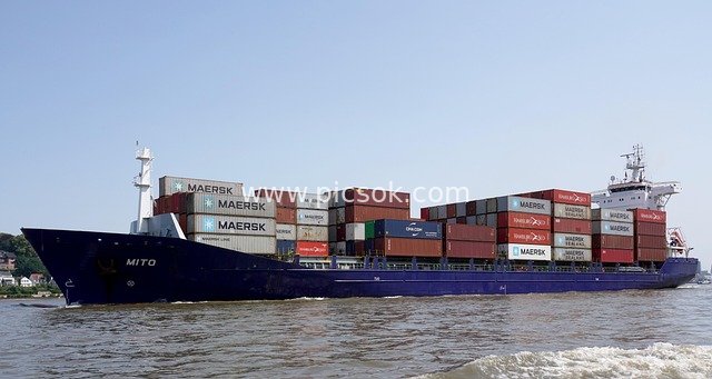 Blue Cargo Ship Transporting Containers at Hamburg Port: A Logistics Scene