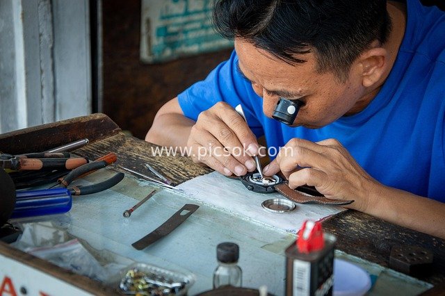Watchmaker Focused on Watch Repair - Close-up of Professional Tools and Magnifying Glass