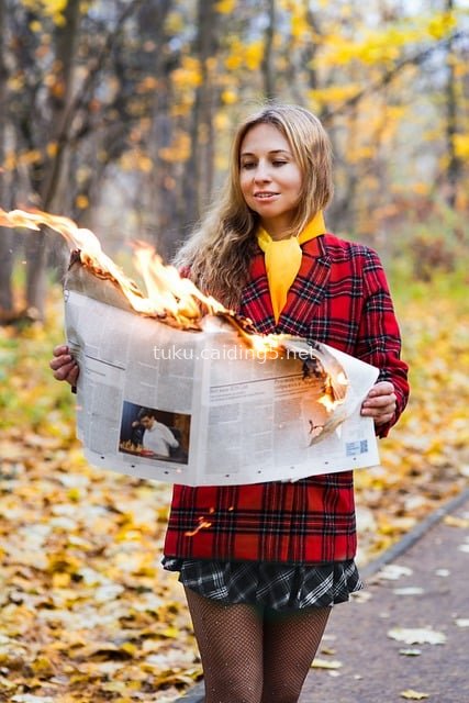 秋日公园美女持燃烧报纸 格纹外套秋日时尚