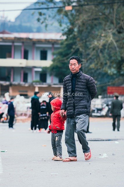 越南老街市场中父女同行的日常生活瞬间