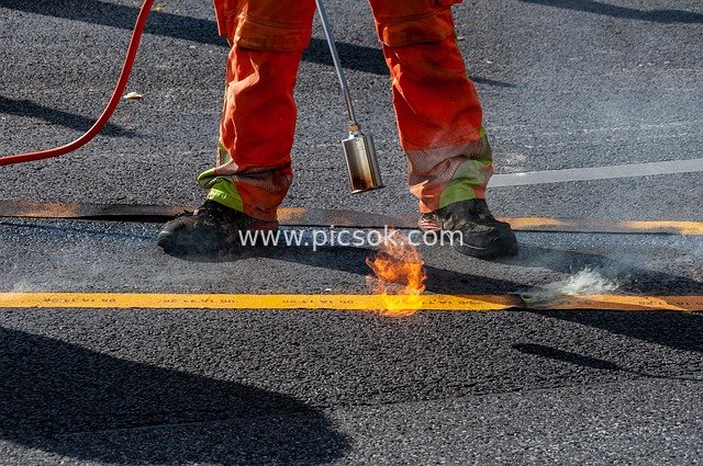 On-site Photo of Construction Workers Performing Road Marking Repair Work