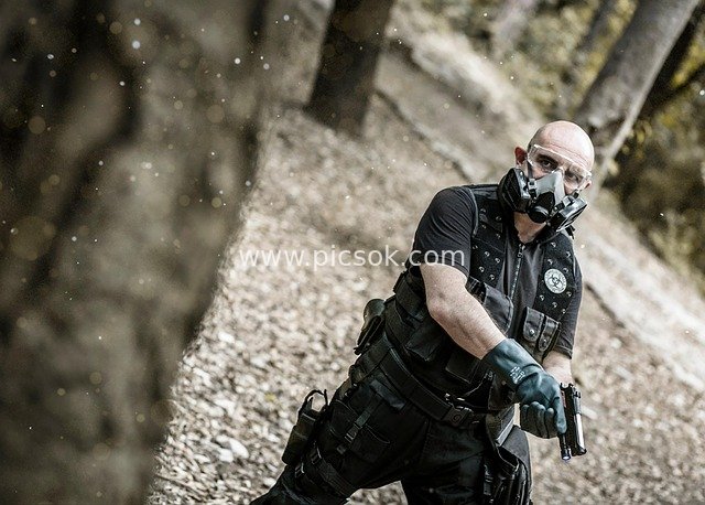 森林中戴防毒面具的武装人员持手枪警戒