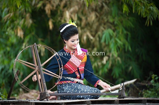 Traditional Weaving Technique: Woman in Ethnic Costume Spinning Outdoors