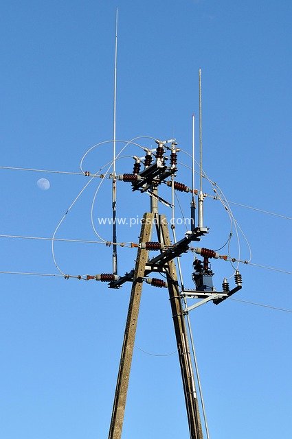 Electric Utility Poles and Wiring Setup Against a Clear Blue Sky