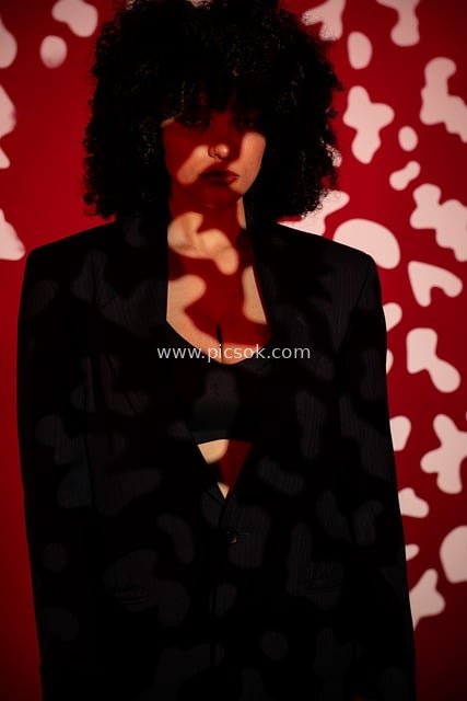 Fashion Art Portrait of a Woman with Curly Black Hair – Red Background & Light and Shadow