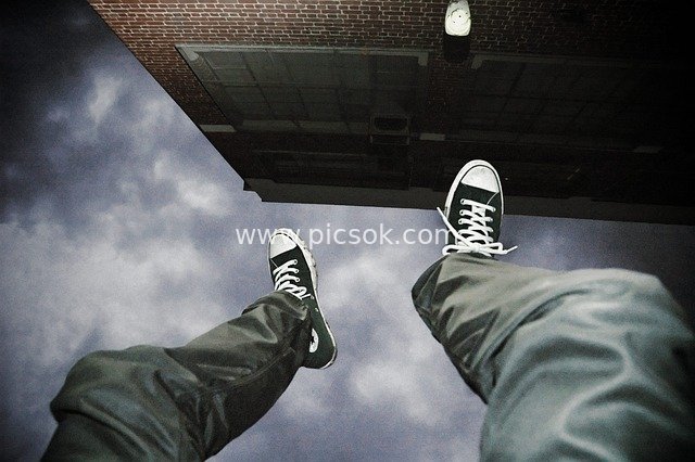 Man Hanging Upside Down at Height: Creative Image of a Dangerous Fall Moment