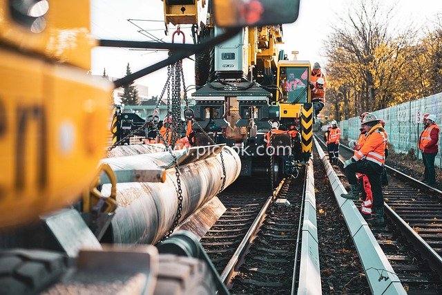 Railway Track Construction Site: Crane Lifting Pipeline Operation