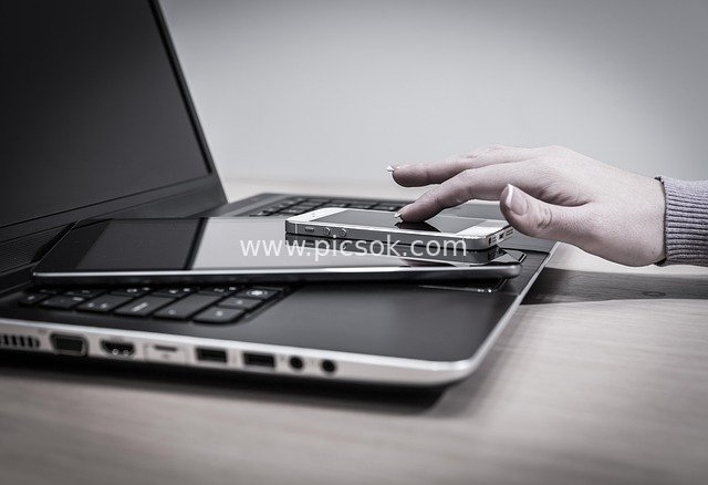 Business Office Electronic Devices: Tech Interaction Scene of Laptops, Tablets and Smartphones