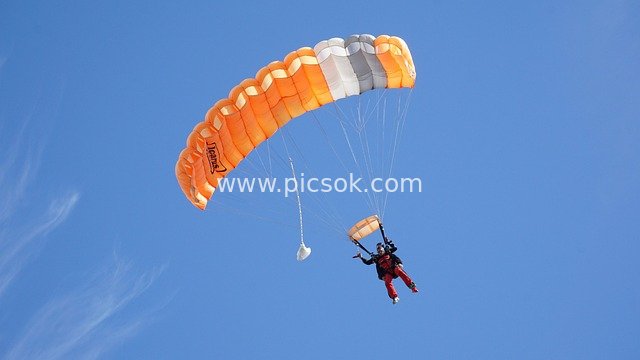 双人跳伞翱翔蓝天 橙色降落伞尽显活力