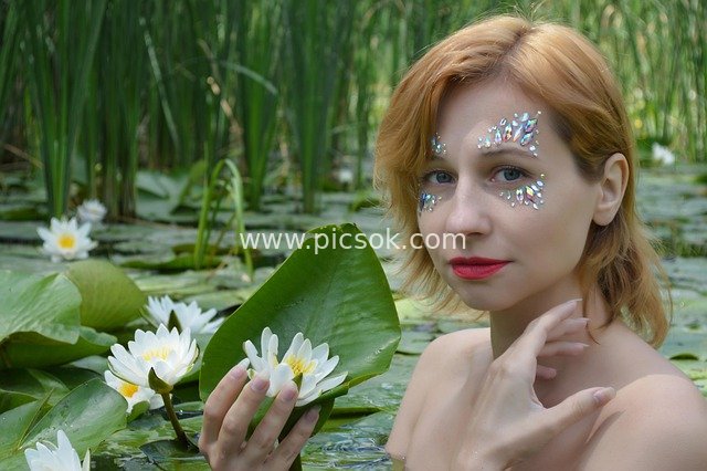 Fresh Portrait of a Red-haired Woman with Water Lilies in a Natural Pond