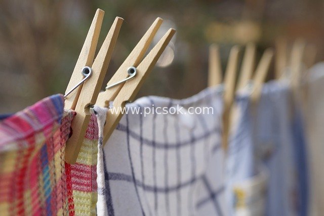 Close-up of Wooden Clothespins Holding Drying Laundry Outdoors