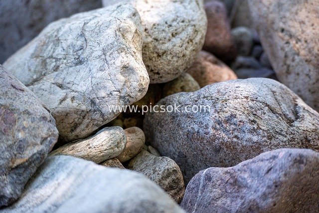 Summer Mediterranean Riverbed Pebble Pile: Tranquil Relaxing Background with Natural Light and Shadow