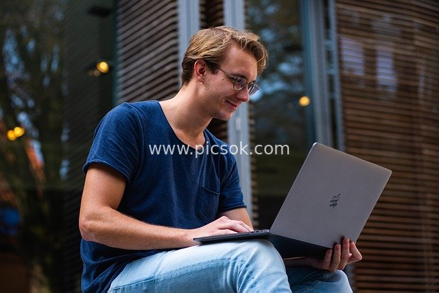Young Teacher Working Outdoors with Apple Laptop in Educational Context